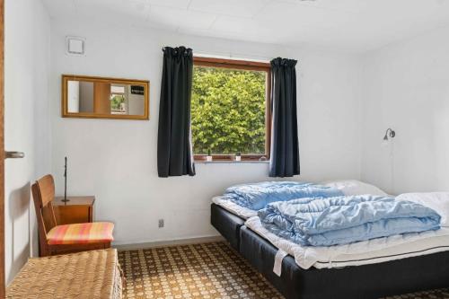 un dormitorio con una cama y una ventana en Cozy Cottage Near Beach And Nature, en Vesterby