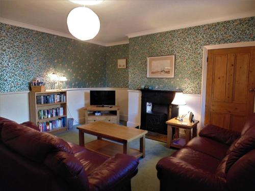 a living room with a couch and a coffee table at Oswin Cottge in Alnwick