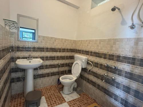 a bathroom with a toilet and a sink at Oasis Guest House Bhagsu D'shala in Dharamshala