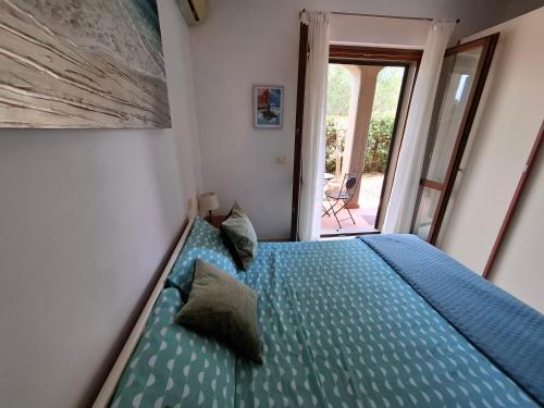 モンテメラノにあるAppartamento tra il mare e le Terme di Saturniaの青いシーツと枕が備わったベッドのある寝室