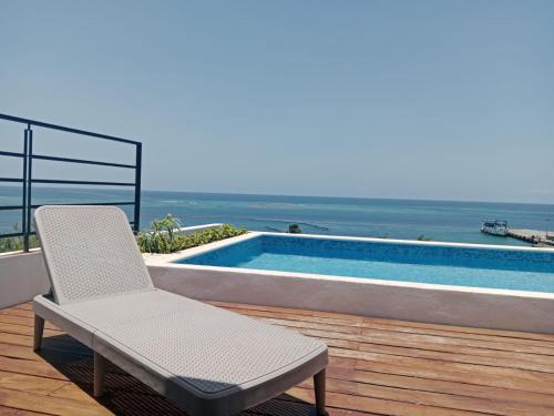 a chair sitting on a deck next to a swimming pool at Turix 103 in Puerto Morelos