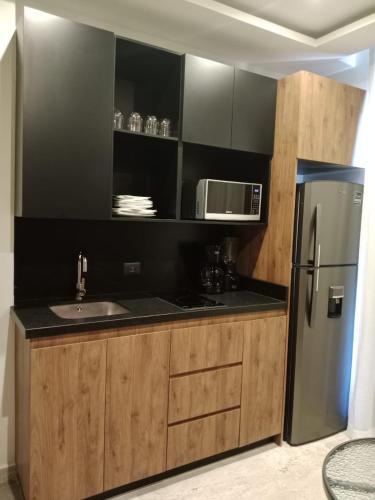 a kitchen with a stainless steel refrigerator and a microwave at Turix 103 in Puerto Morelos
