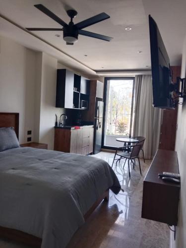 a bedroom with a bed and a kitchen with a table at Turix 103 in Puerto Morelos