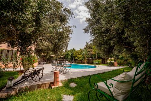 a park with a pool and benches and trees at Chalet berbère 2 Chambres avec Piscine &Wifi fibre in Essaouira