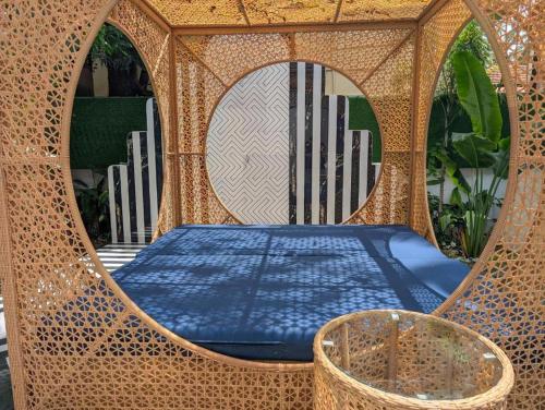 a bed in a wicker structure with a mirror at Villa Candolim in Candolim