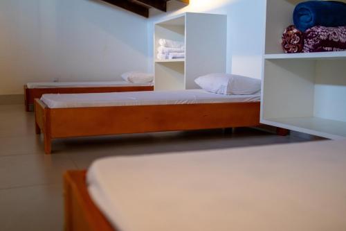 a room with two beds and a shelf at Pousada Flor de Piri in Pirenópolis