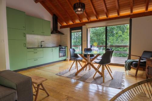 a kitchen with green cabinets and a table and chairs at Quinta da Fenteira - Casa Tora in Arcos de Valdevez
