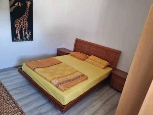 a bed in a room with a giraffe picture on the wall at Apartma Olivia in Šmarje