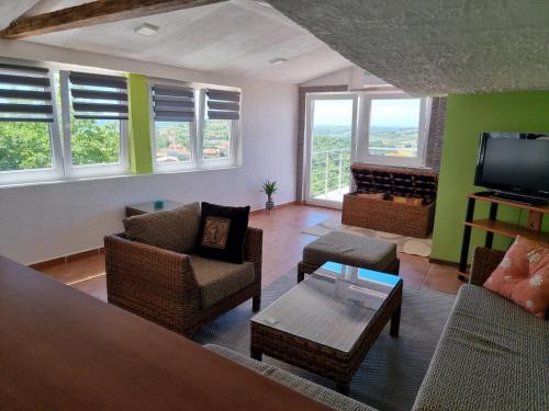 a living room with chairs and a tv and a fireplace at Apartma Olivia in Šmarje