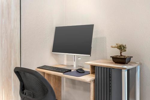 a desk with a computer monitor and a chair at MainStay Suites Little Rock West Near Medical Centers in Little Rock