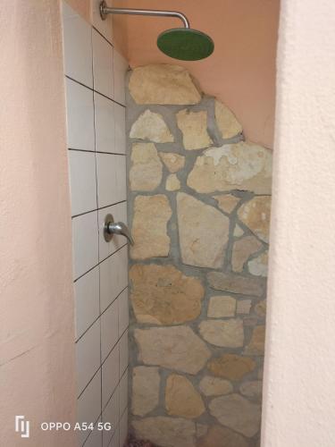 a bathroom with a shower with a stone wall at casa relax a chia in Chia