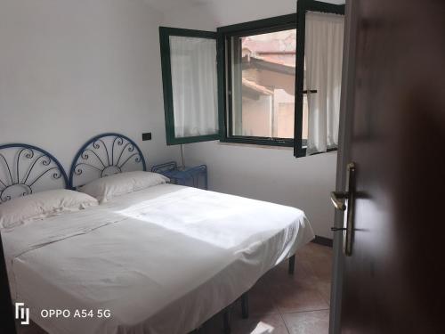 a bedroom with a bed with white sheets and a window at casa relax a chia in Chia