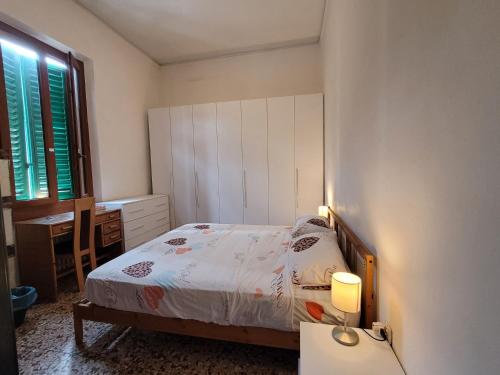 a bedroom with a bed and a desk and a window at Ampia camera vicina al centro in Florence