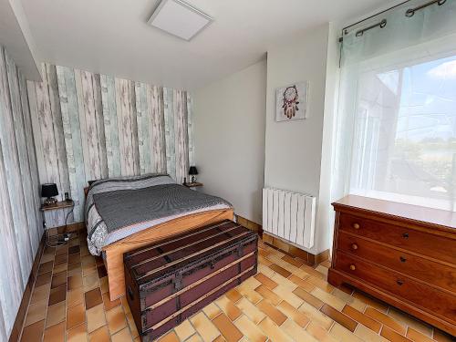 a bedroom with a bed and a dresser and a window at Appartement Salines 46m2 in Carnac
