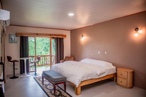 a bedroom with a bed and a balcony at Hotel del Bosque in Río Cuarto