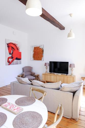 a living room with two couches and a tv at Bordeaux Village Blaye in Blaye