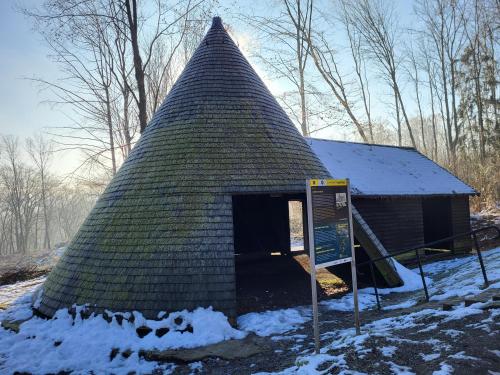 a small building with a pointed roof in the snow at Ferienwohnung Muttental in Witten