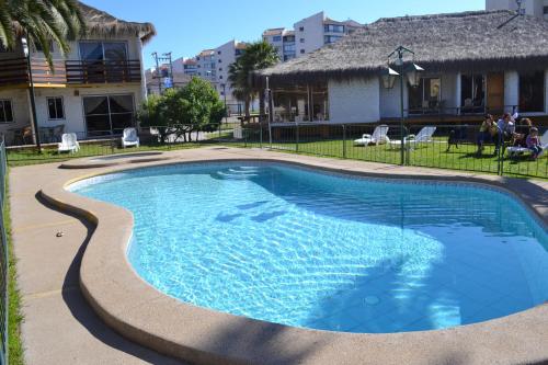 a swimming pool in front of a house at Cabañas Las Añañucas I in La Serena