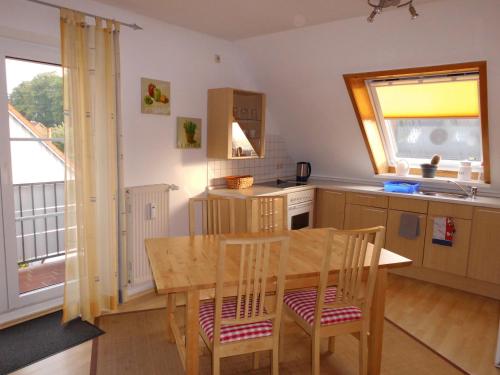 Ferienwohnung am Selenter See في Selent: مطبخ مع طاولة وكراسي خشبية في مطبخ