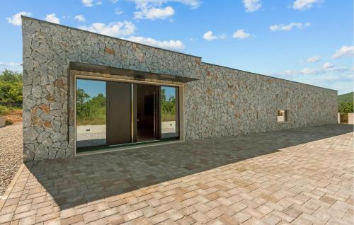 a stone building with a large window on it at Beautiful Home In Dicmo in Dicmo