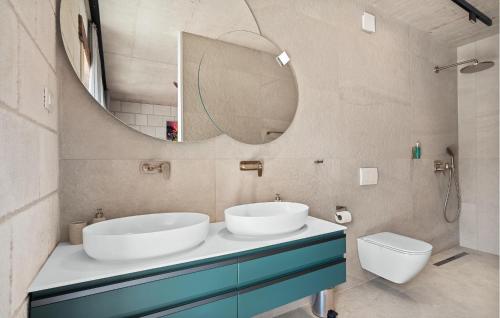 a bathroom with two sinks and a mirror at Beautiful Home In Dicmo in Dicmo
