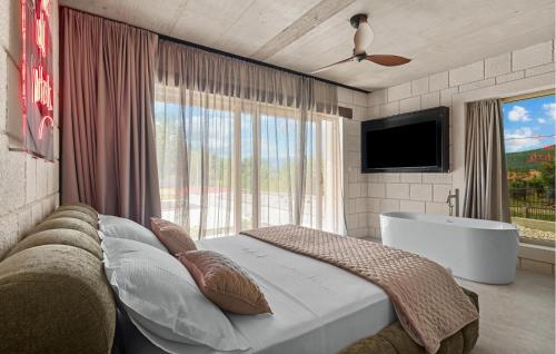 a bedroom with a bed and a tub and a television at Beautiful Home In Dicmo in Dicmo