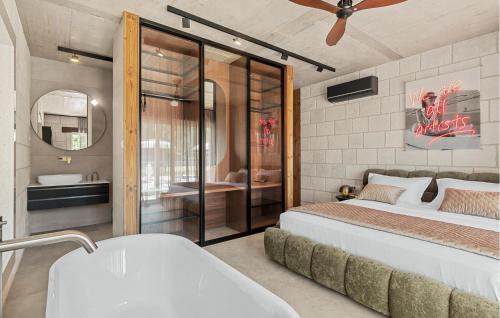 a bathroom with a bed and a bath tub and a tub at Beautiful Home In Dicmo in Dicmo