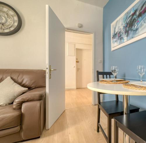 a living room with a couch and a table at Le Saint Fiacre in Compiègne