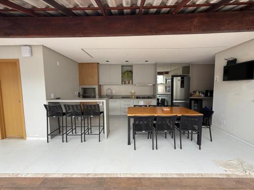 an open kitchen with a wooden table and chairs at Casa Caju Lençóis in Barreirinhas