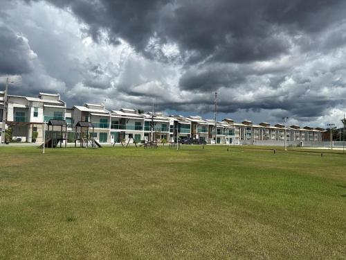 a building with a playground in front of a field at Casa Caju Lençóis in Barreirinhas