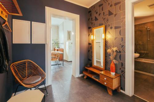 ein Badezimmer mit einem Stuhl und einem Spiegel in der Unterkunft Ferienwohnung Feel Good Apartment - zentrale 65qm Design Fewo im Zittauer Gebirge - bahnhofsnah in ruhiger Lage in Zittau