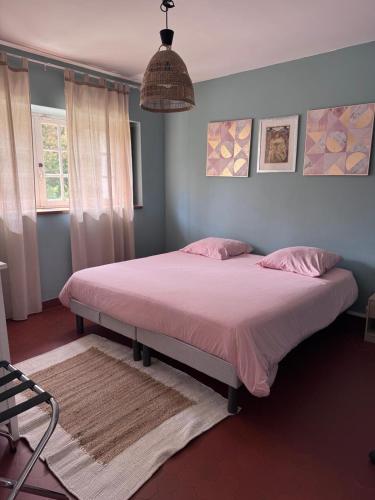 - une chambre avec un grand lit et des draps roses dans l'établissement Le Mousseau Proche de Chambord, à Mer