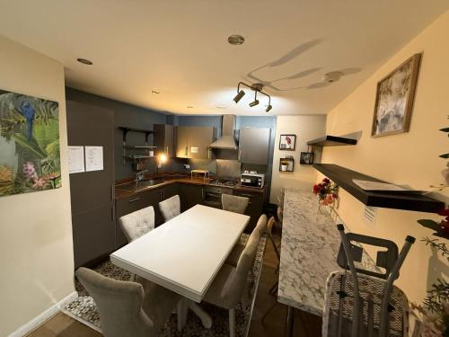 a kitchen and dining room with a white table and chairs at Property Near Canary Wharf in London
