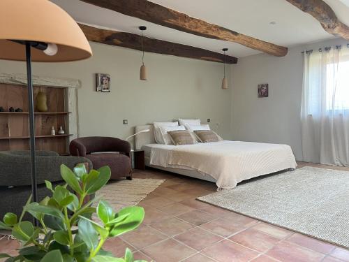 a bedroom with a bed and a living room at Maison Casamande & SPA - Luxe et sérénité dans un domaine d'amandiers in Bouquet