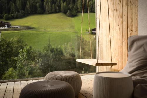 a room with a balcony with a large window at Naturhotel Rainer in Racines