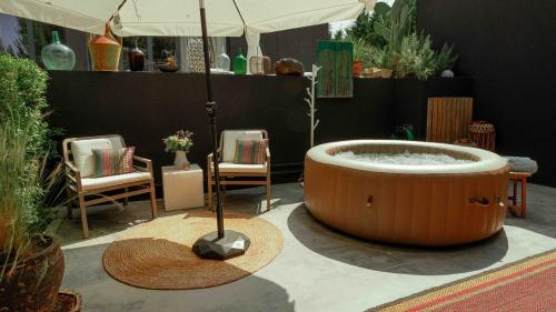 a hot tub in a room with chairs and an umbrella at Privat Atelier in Setúbal