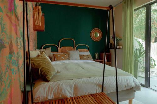 a bedroom with a canopy bed with a green wall at Privat Atelier in Setúbal