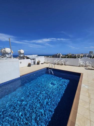 a swimming pool on the roof of a building at Stylish 2BR Apartment with Rooftop Pool in Mackenzie in Larnaca