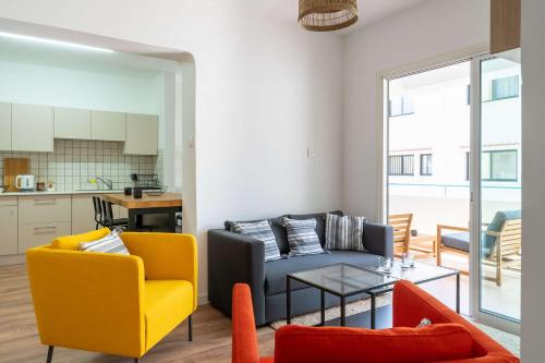 a living room with a couch and a table at Stylish 2BR Apartment with Rooftop Pool in Mackenzie in Larnaca