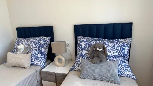 a bedroom with two beds with a teddy bear sitting on a pillow at Cosy Apartment in a Secured Compound of PlayaSol with Large Pools in Vinaròs