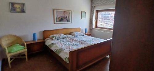 Un dormitorio con una cama y una silla y una ventana. en Villa des Collines, en Malmedy