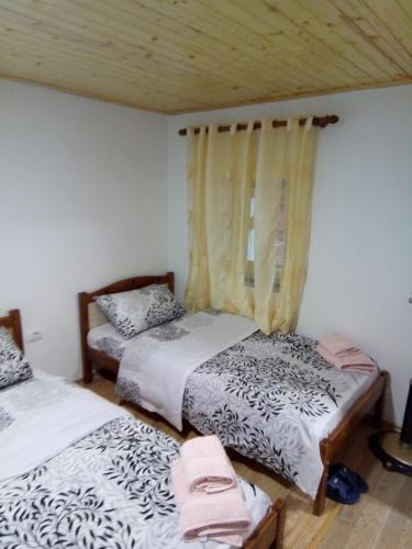 a bedroom with two beds and a window at Bujtina Sherifaj in Valbonë