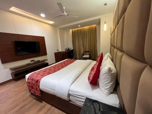 a hotel room with a bed and a flat screen tv at Hotel The Crystal Park in Gwalior