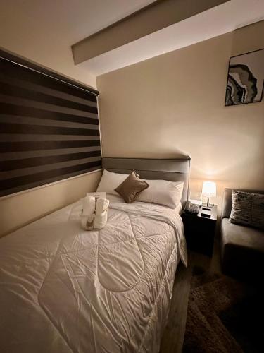 a bedroom with a bed with two towels on it at South Breeze Stay Near Nuvali, Enchanted kingdom, Tagaytay in Silang