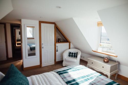 una camera da letto con un letto, una sedia e una finestra di Shell Cottage B&B a Toscaig