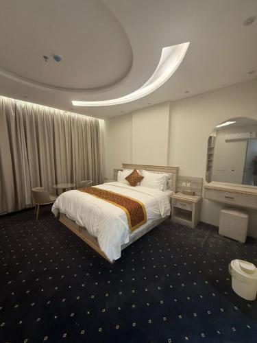 a hotel room with a large bed and a mirror at فوج فيو للفلل والشقق الفندقية in Al Namas