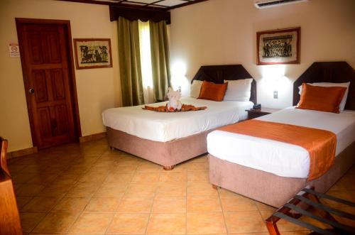 two beds in a hotel room with two beds sidx sidx sidx at El Tucano Resort & Thermal Spa in Quesada