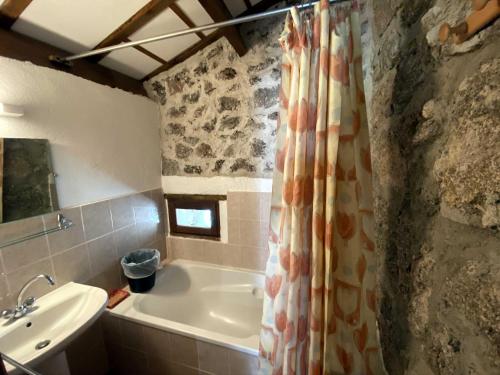 ein Badezimmer mit Badewanne und Waschbecken in der Unterkunft Maison des Cévennes in Arphy