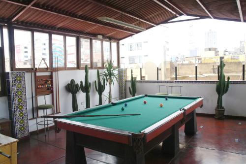 a pool table in a room with cactus at Hostal Iquique in Lima
