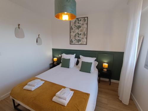 une chambre avec un lit avec deux serviettes dessus dans l'établissement le contemporain, à Bastia